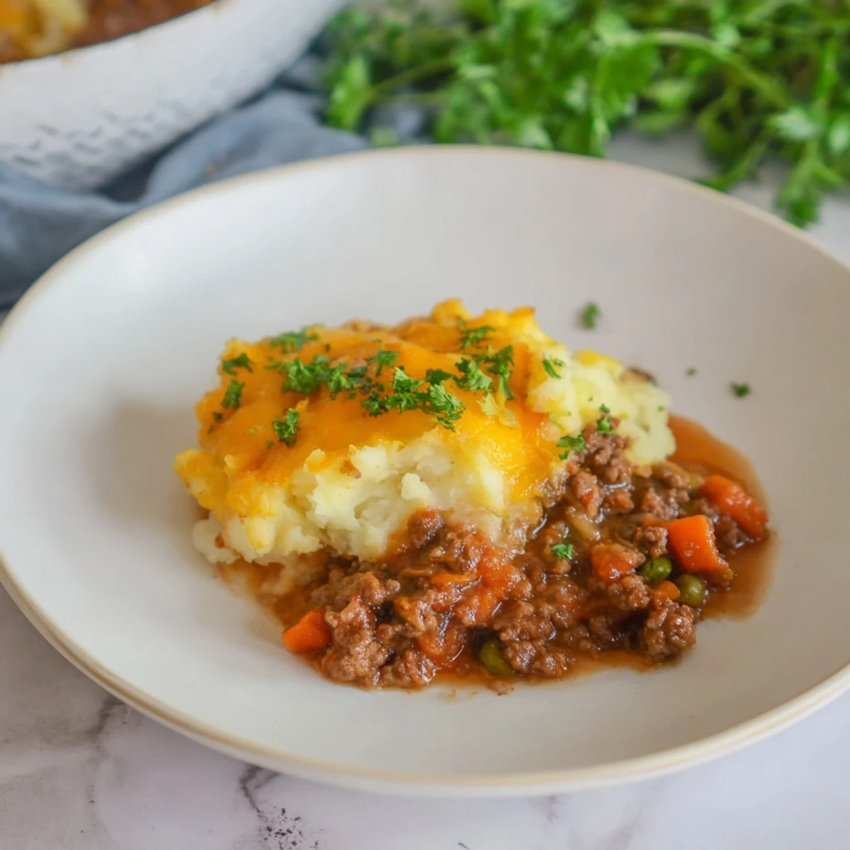 A steaming, hearty warm Rustic Shepherds Pie, with rich lamb and vegetable filling, topped with cheese.