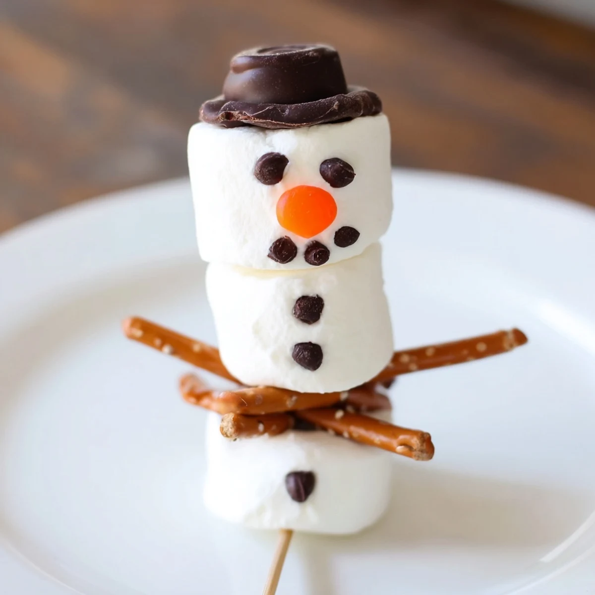 Marshmallow Snowman Stick Arrangement: Sweet, smiling marshmallow snowmen ready for a festive winter treat, decorated with care.