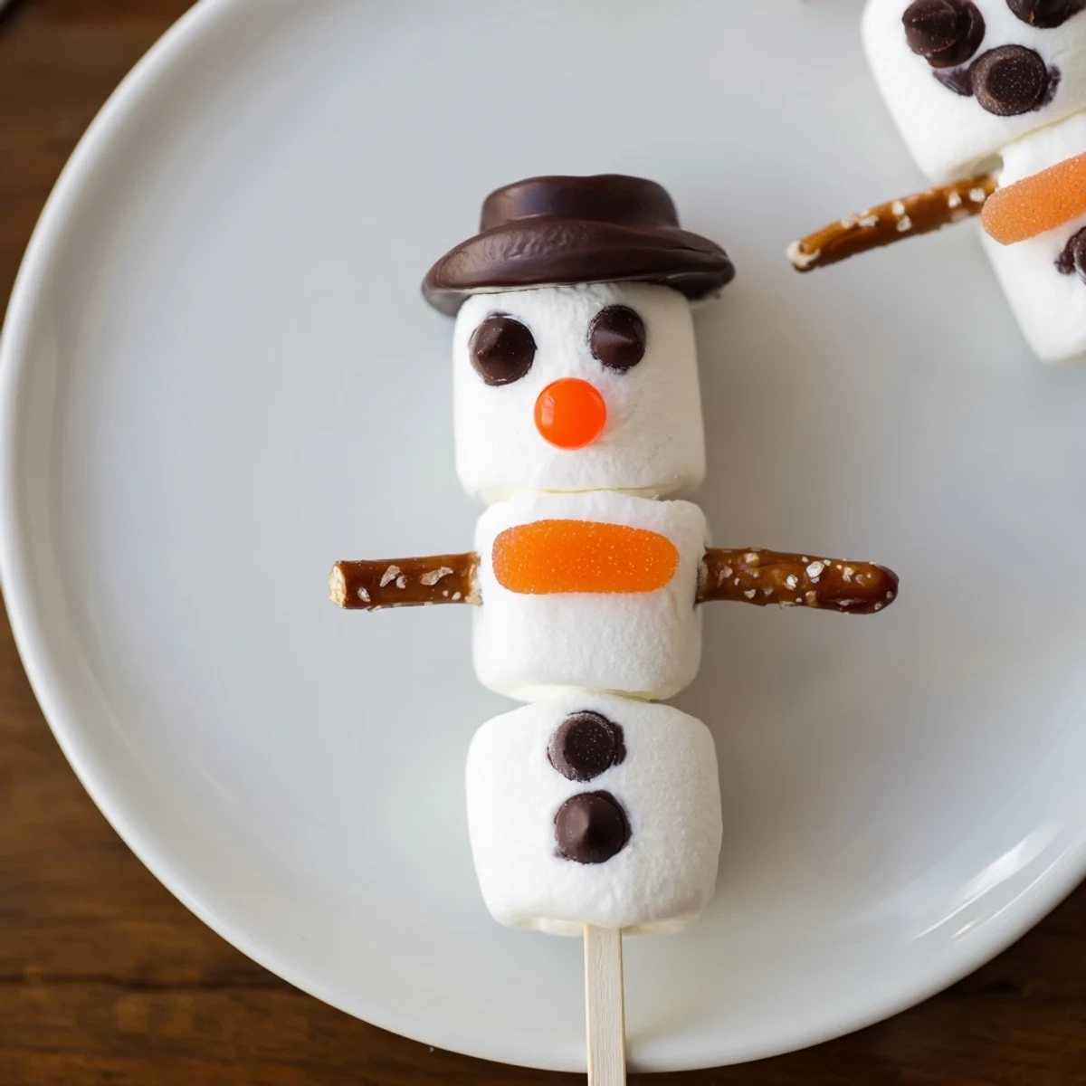 Enjoy colorful Marshmallow Snowman Stick Arrangement decorations: pretzel arms, chocolate faces, and tasty hats for a fun dessert.