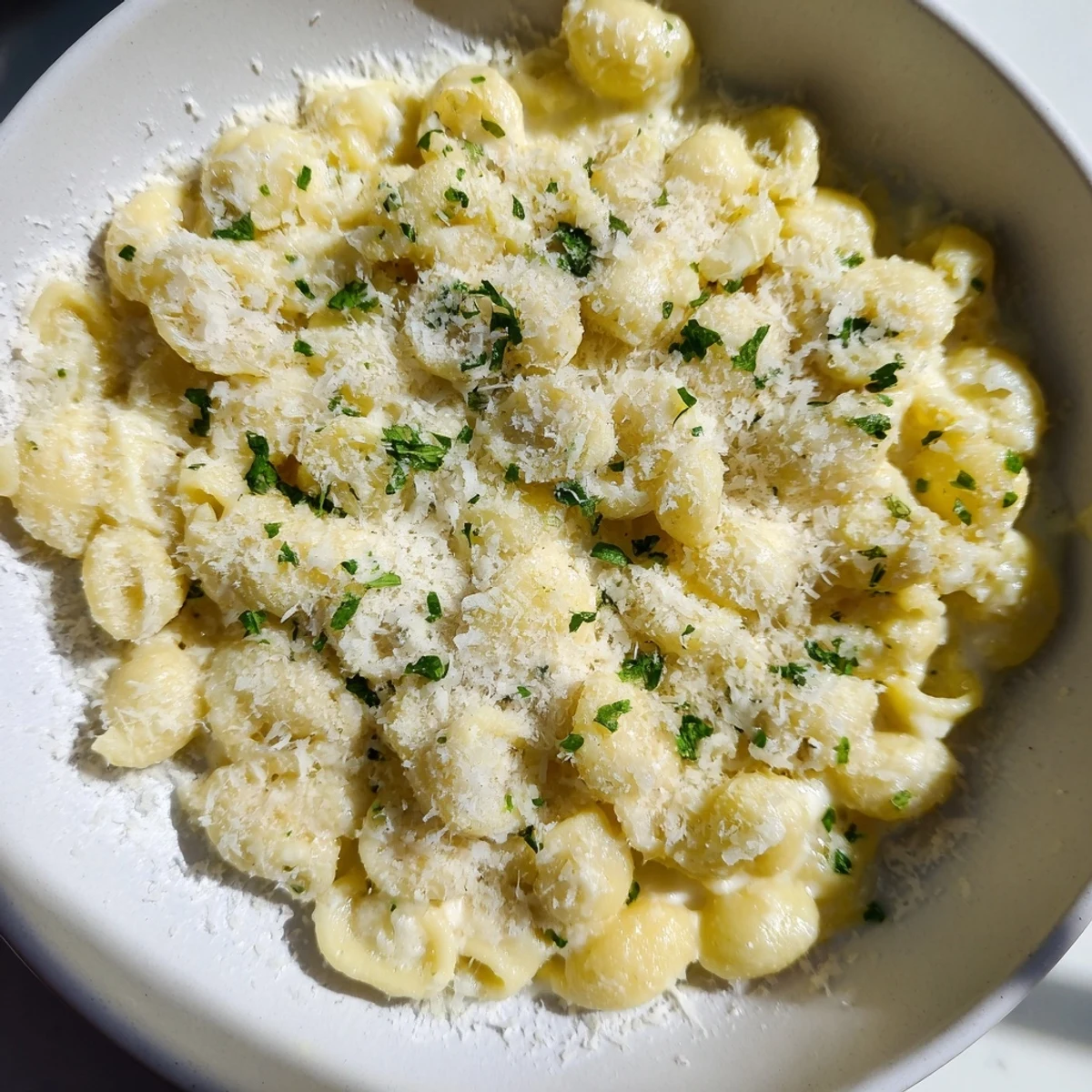 Steaming bowl of 15-Minute Garlic Parmesan Pasta, creamy and fragrant with plenty of grated Parmesan.