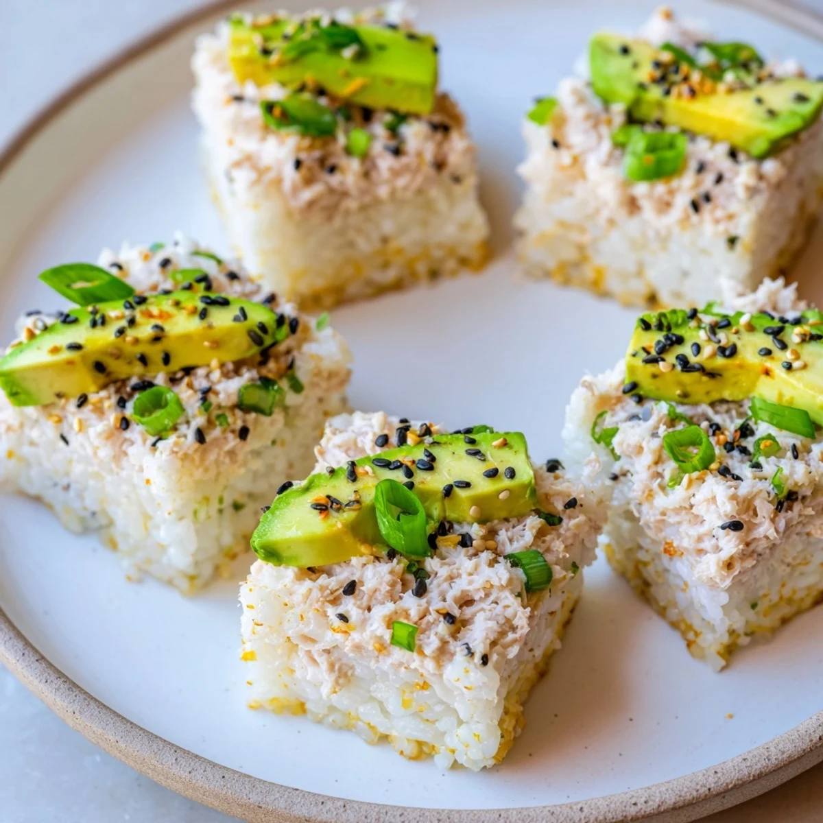 Crispy rice squares, topped with spicy tuna, garnished with avocado are a beautiful Japanese-American fusion dish.