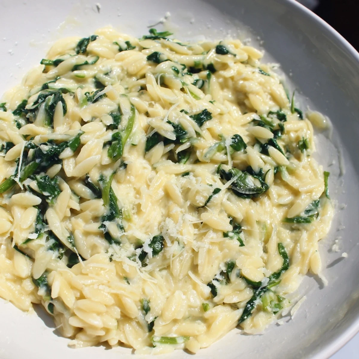 A close-up of creamy spinach orzo, a comforting vegetarian pasta dish ready to serve.