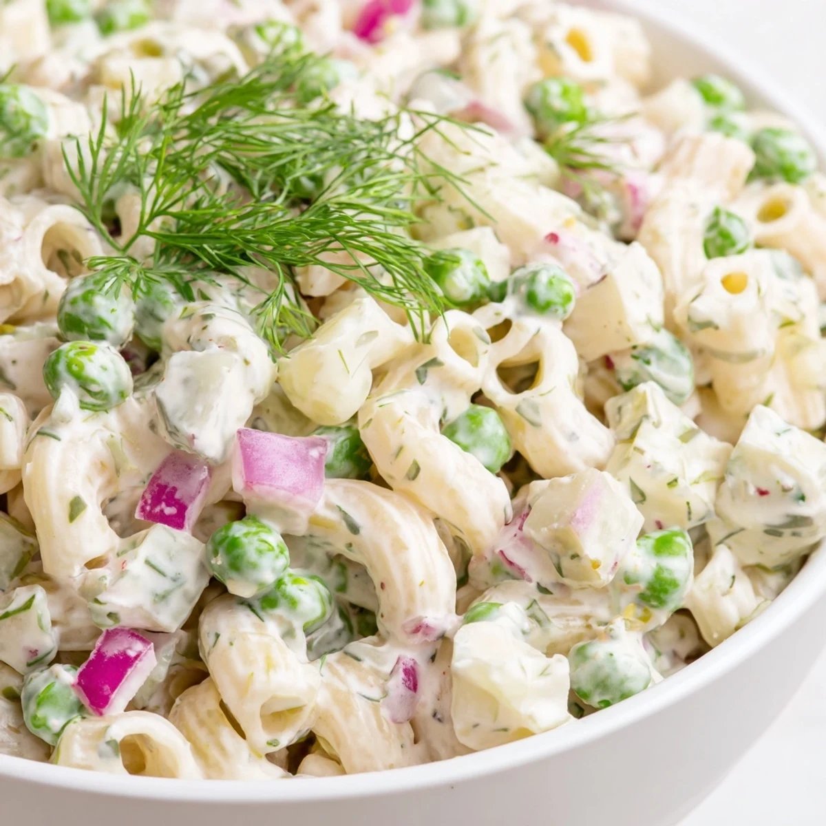 Creamy dill pickle pasta salad with crunchy ditalini, peas, and dill pickles in a zesty dressing, perfect alongside grilled chicken.