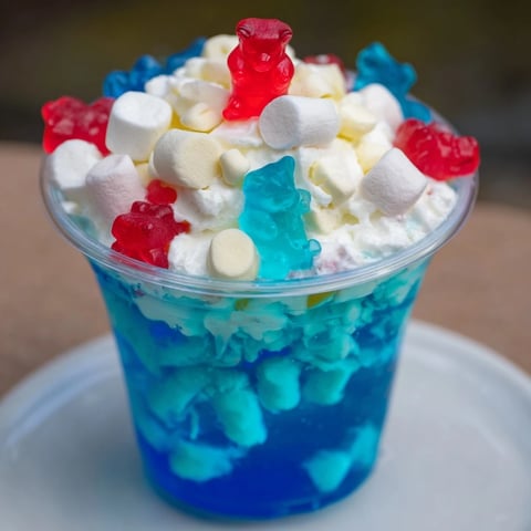 Snow globe Jello cups gleam with blue gelatin, studded with marshmallows and festive sprinkles; a yummy holiday treat.