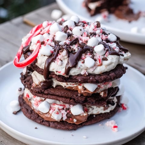 Warm, inviting image: stacked Hot Cocoa Mug Cookie desserts drizzled with melted chocolate and marshmallows.