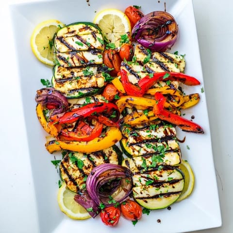 Perfectly charred vegetarian halloumi cheese steak garnished with fresh parsley and served alongside juicy halved cherry tomatoes.  