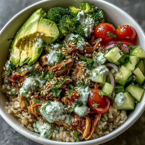 Customizable rotisserie chicken bowl featuring tender chicken, crisp veggies, and your choice of sauce for a quick, healthy meal.  
