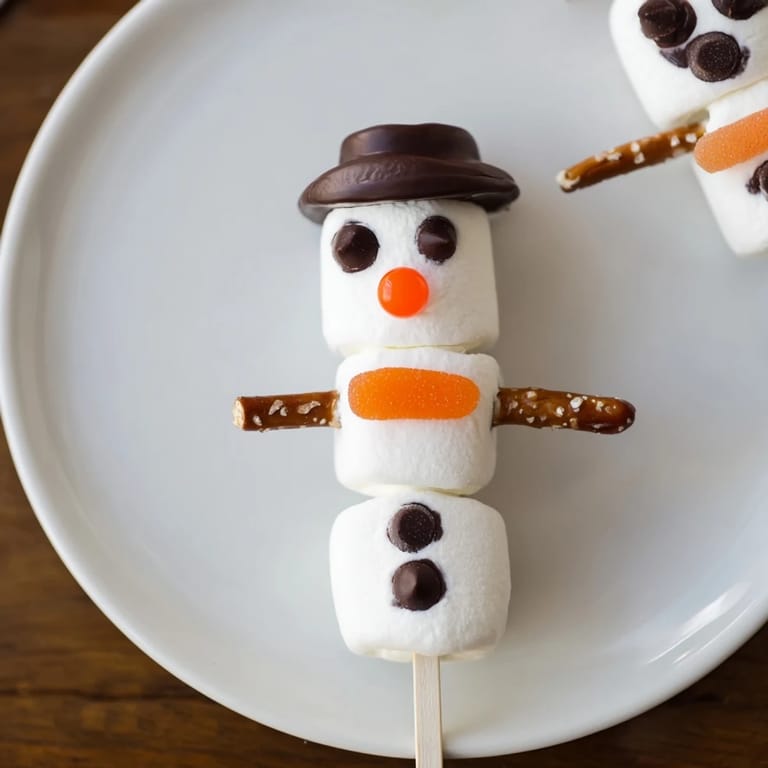 Enjoy colorful Marshmallow Snowman Stick Arrangement decorations: pretzel arms, chocolate faces, and tasty hats for a fun dessert.